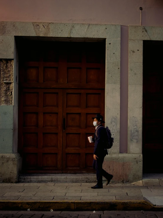 a man in a mask walks by an open door