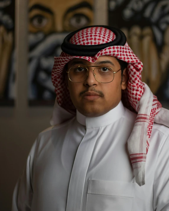 a man is wearing a white shirt with a checkered scarf on top of his head