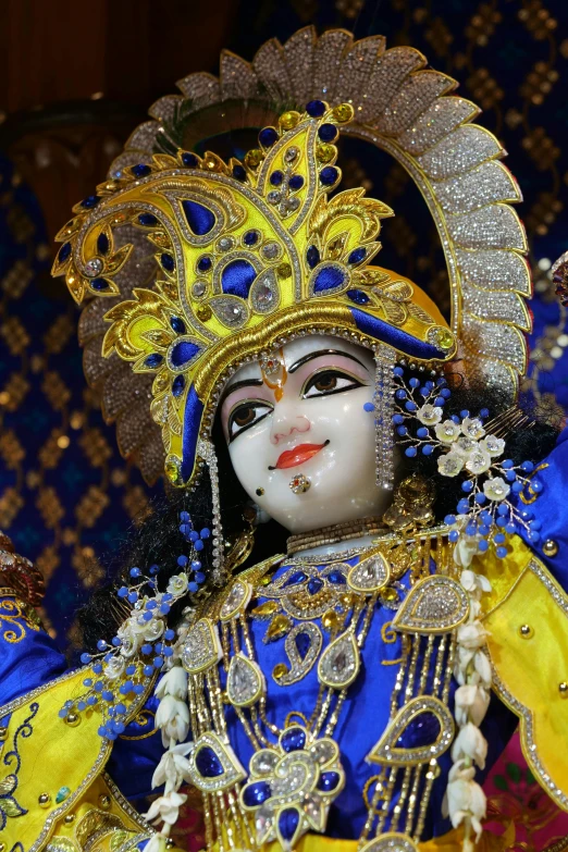 an elaborately dressed dancer holds his head while looking off