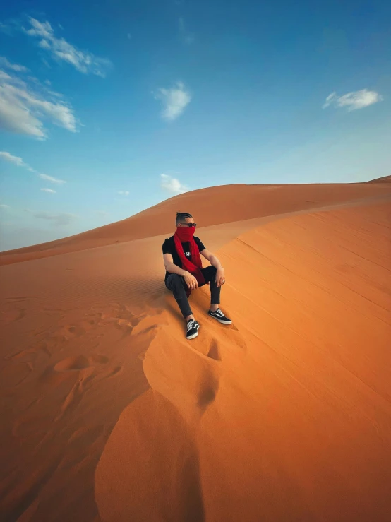 man sitting on top of the sand dunes