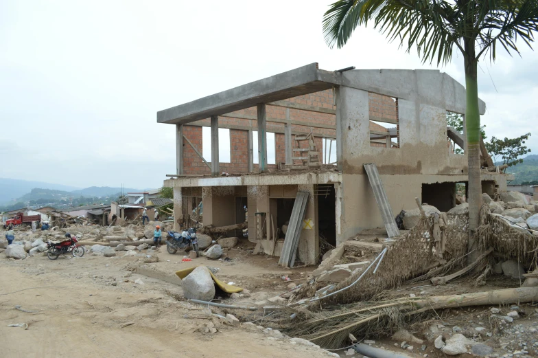 an old and crumbling house sits in a slum of rubble