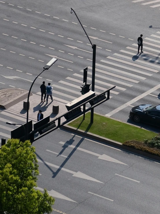 a busy intersection with three pedestrians crossing the street