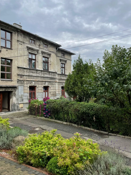 a two story building with several trees on both sides