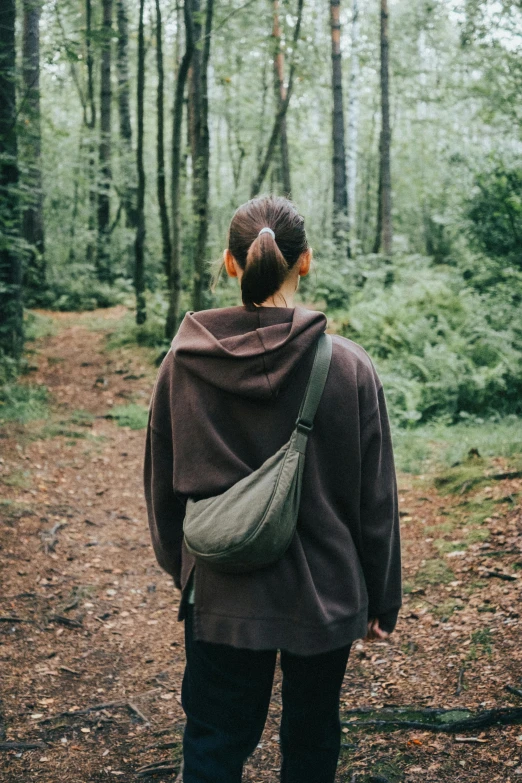 a young woman with backpack on walking in woods