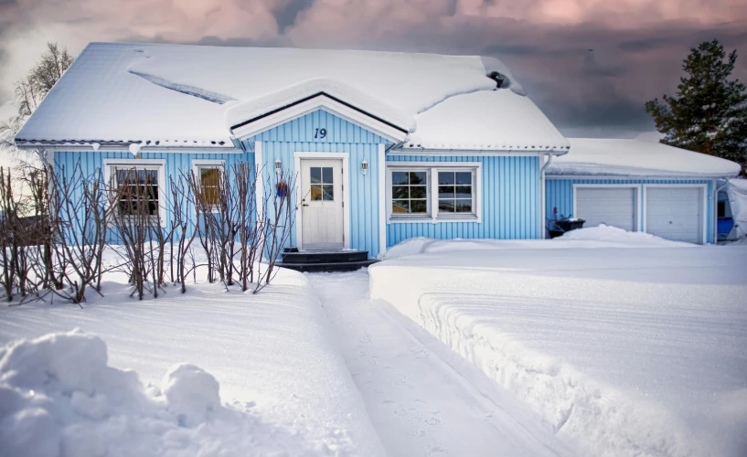 snow on the front of a house and a driveway