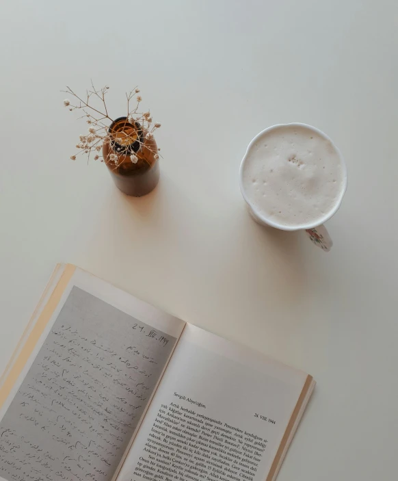 an open book and a coffee cup on a table