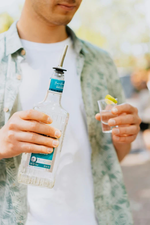 a man standing and holding a bottle of water