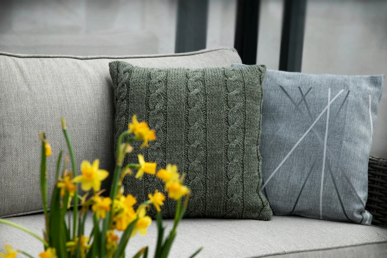 yellow and grey cushions sit on an outdoor bench