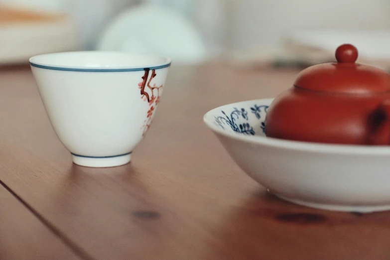 small teapot, coffee mug and porcelain cup sit on a table