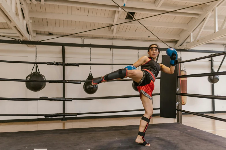 man in kickbox kicking a ball with blue gloves