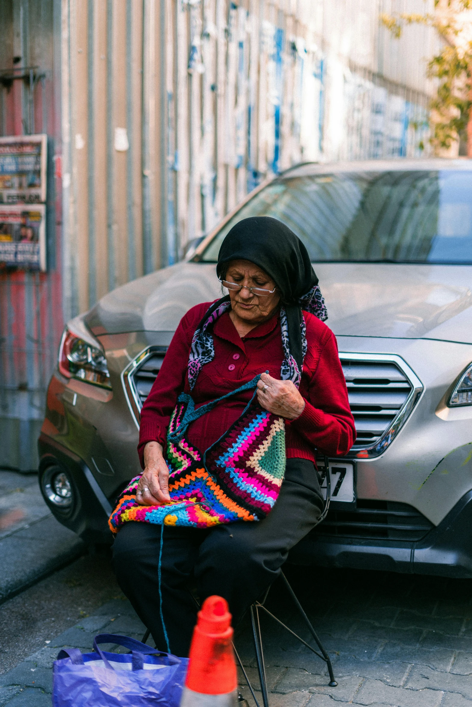 a woman sitting on a stool holding a bag