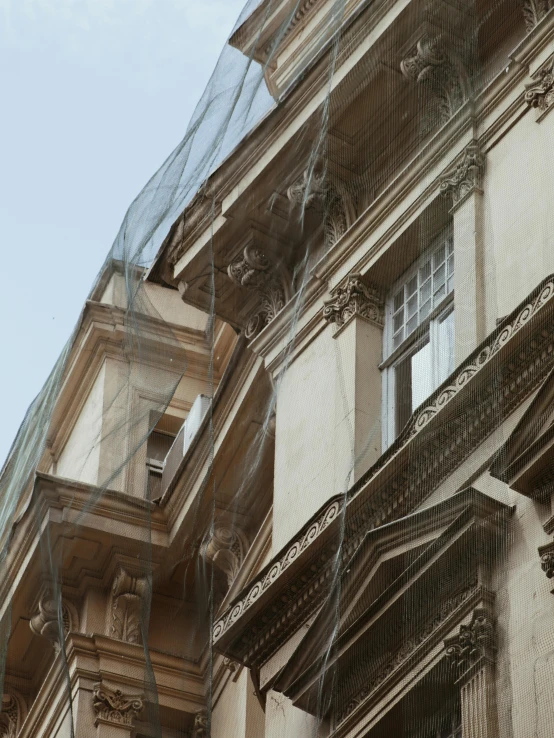 an old style building is seen through the net on a building