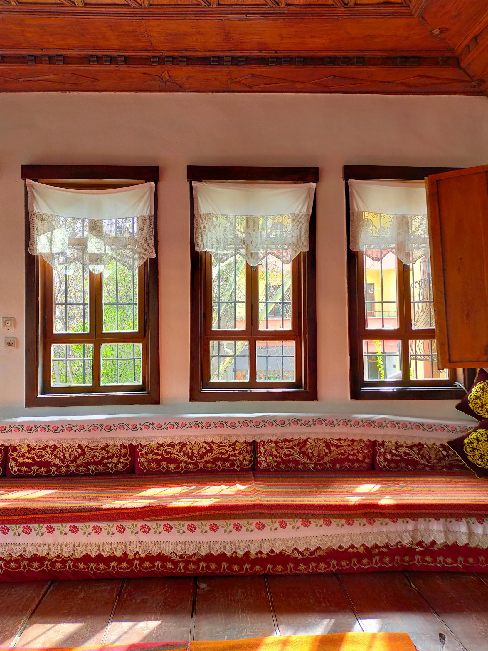 a room with four windows, four red seats and a bench