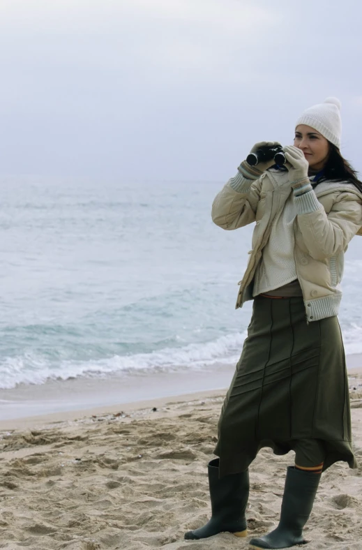 a woman taking a picture of the ocean