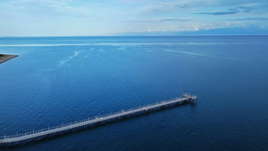 a pier in a big blue body of water