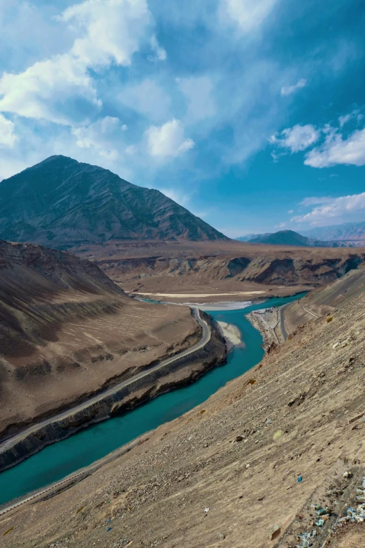 a river is in the foreground with a mountain and cloud in the background