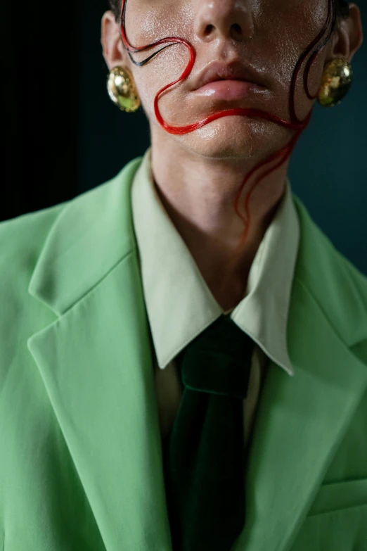 a woman wearing green and a red painted face