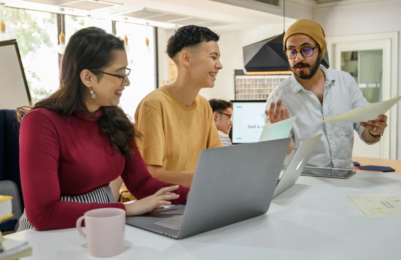 people gathered around a table to discuss what kind of technology they are doing