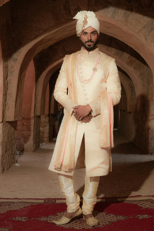 a man dressed in indian clothing standing inside an archway