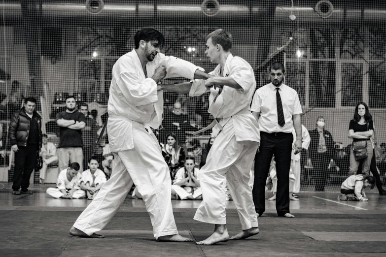 men in white shirts are performing a karate trick