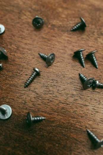 many screws are set on a wooden surface