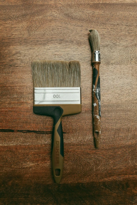 a painting brush sitting next to a paint roller