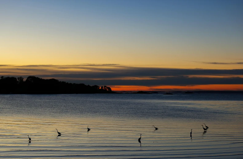 a sunset in the distance over a beach