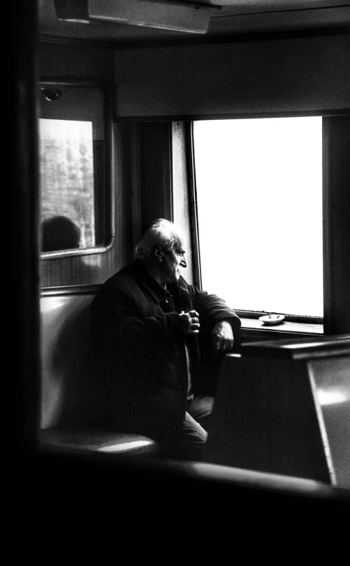 an elderly man in a suit and tie sitting on a subway car