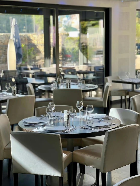 dining tables and chairs are set up with wine glasses