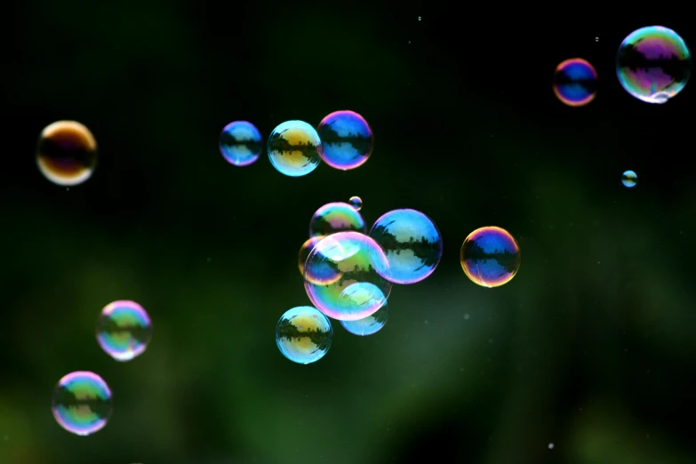 several soap bubbles floating in the air with drops