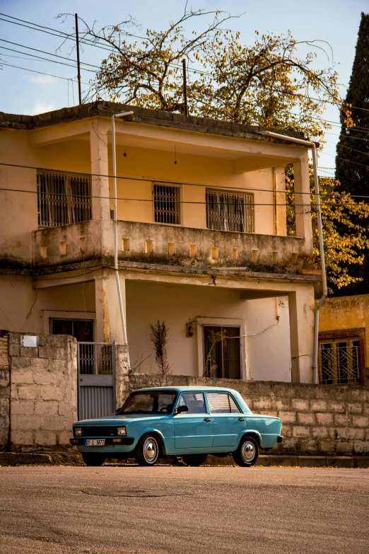 an old, run down building with an old blue truck parked next to it