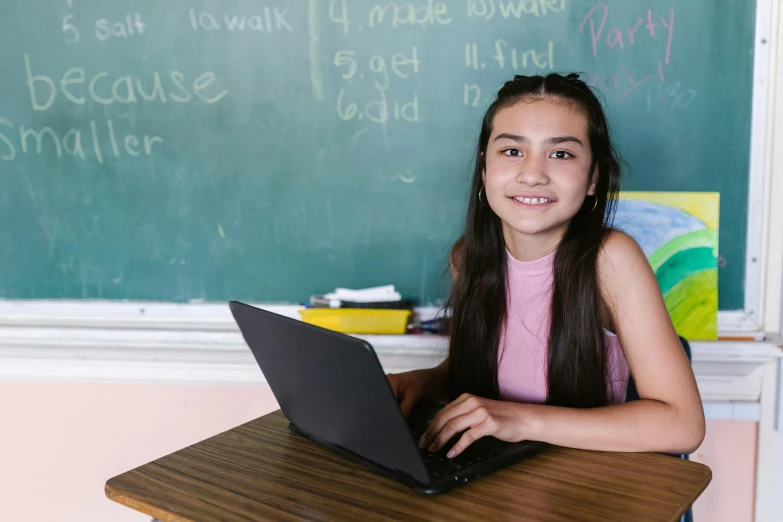 a girl sitting in front of a laptop computer