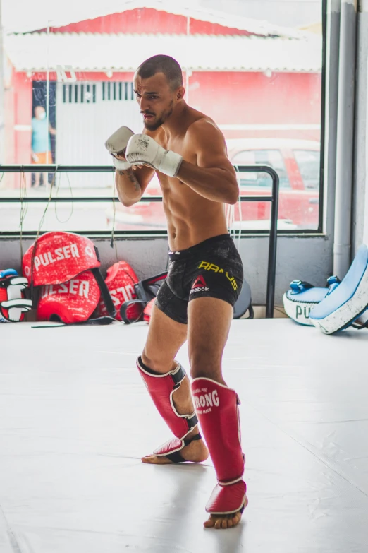 man in boxing pants and boots in the middle of a ring