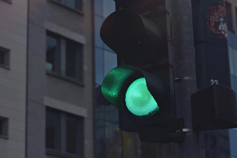 a green traffic signal hanging from a pole