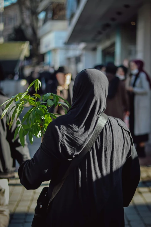 a person in a burka is walking down the sidewalk