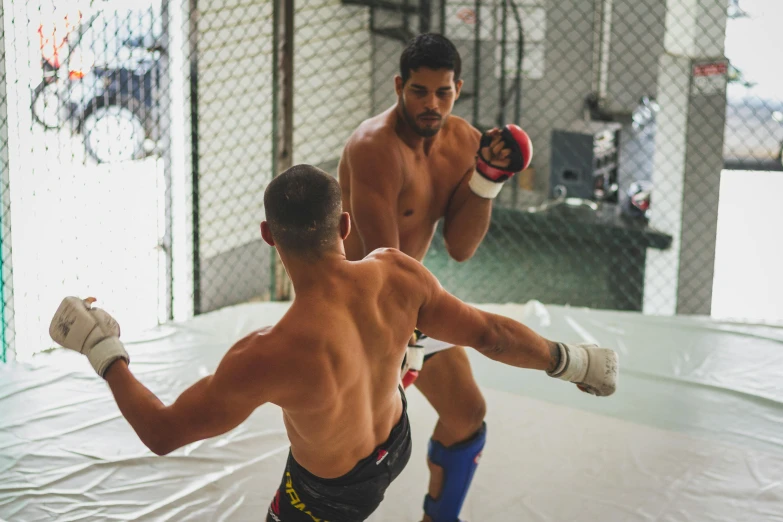 two men are in the middle of kickboxing