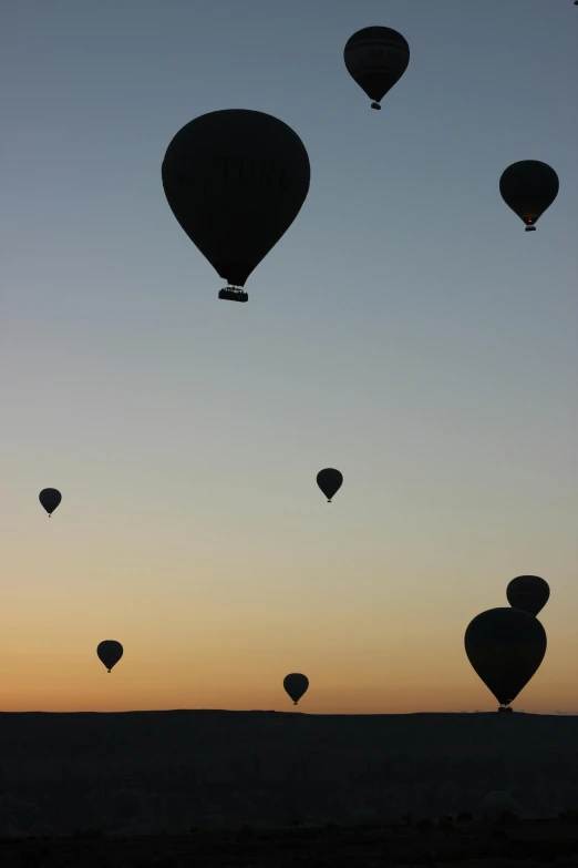 a group of air balloons flying over a desert