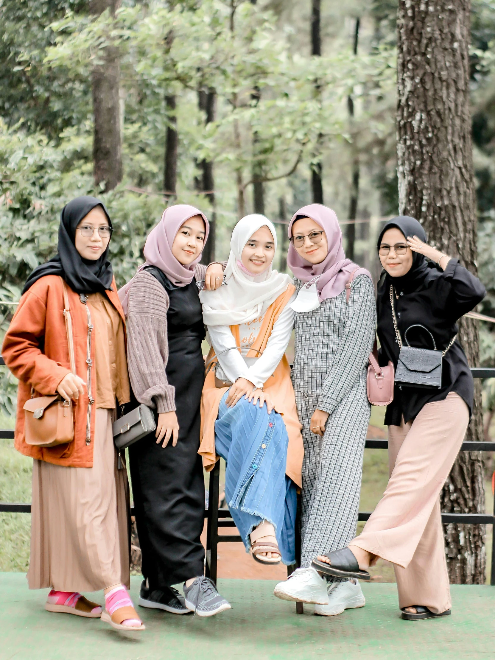 four women pose for the camera in a park