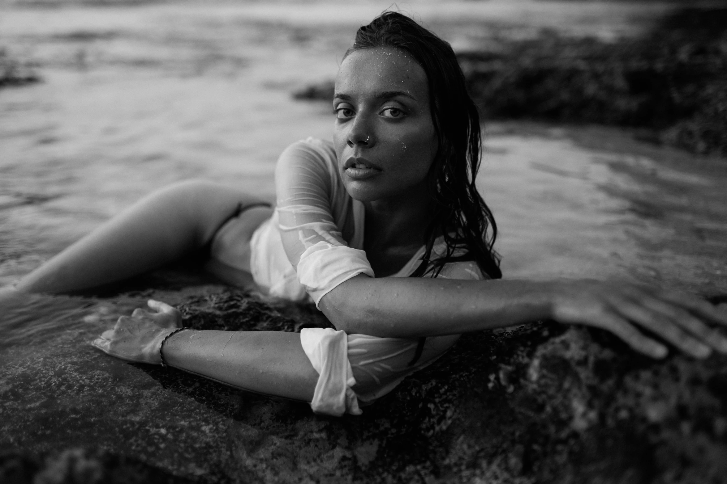 a woman is laying in the water and staring to soing