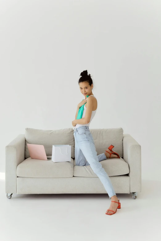 a girl in a top is posing on a couch