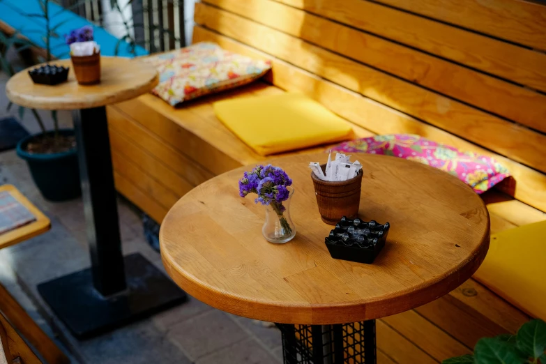 a table on a wooden bench with a bottle of soap and flowers