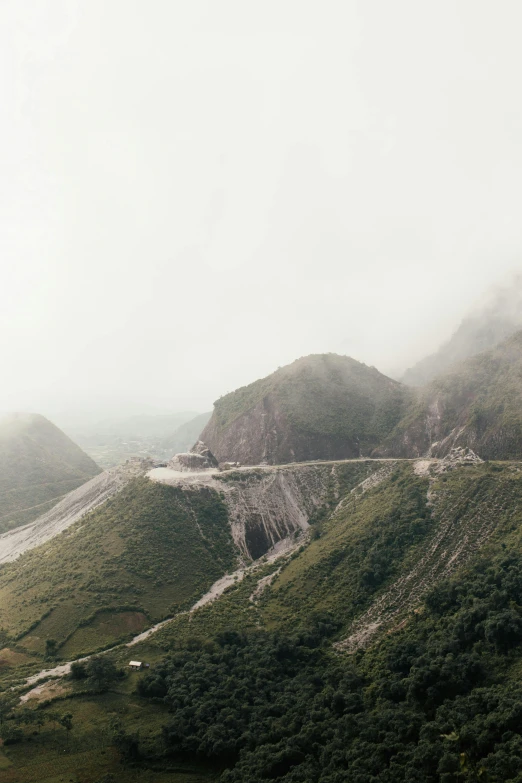 a highway passing by a large mountain covered in fog