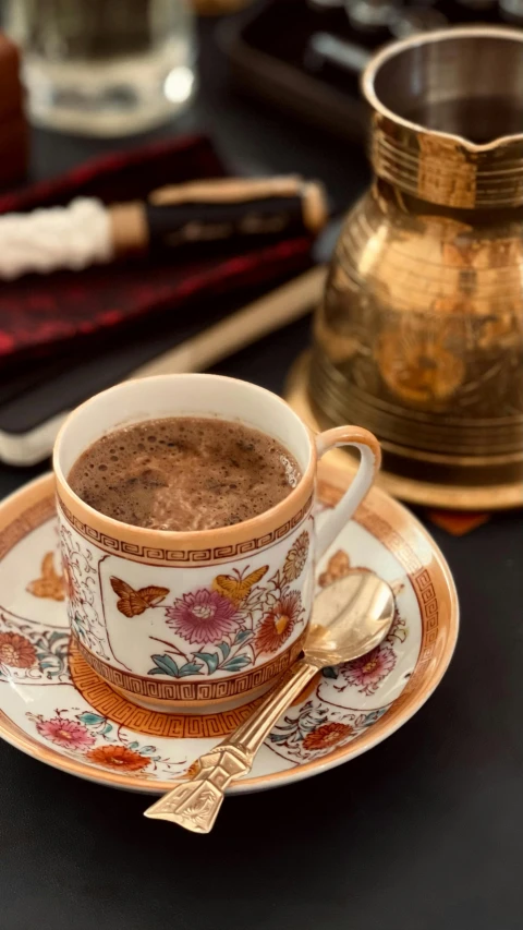 the cup of  chocolate sits on top of a saucer and plate