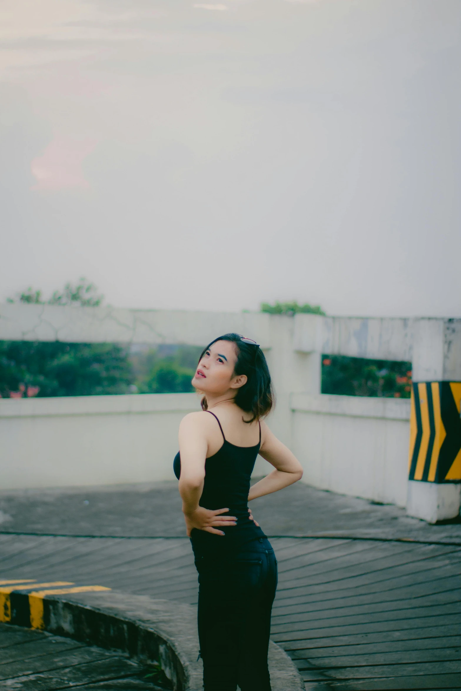 a woman in tight black pants and tank top with her hand on her hip