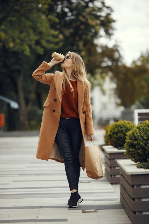 woman walking down the street looking back while holding her hand near her eye