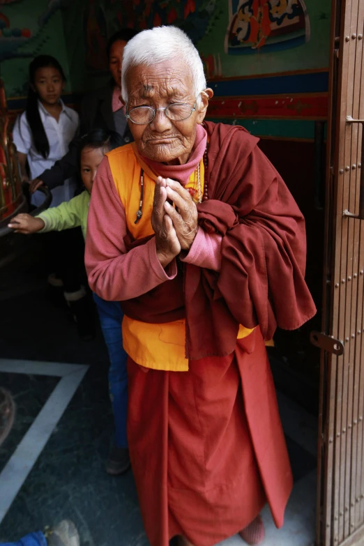 the elderly man is standing outside of a temple