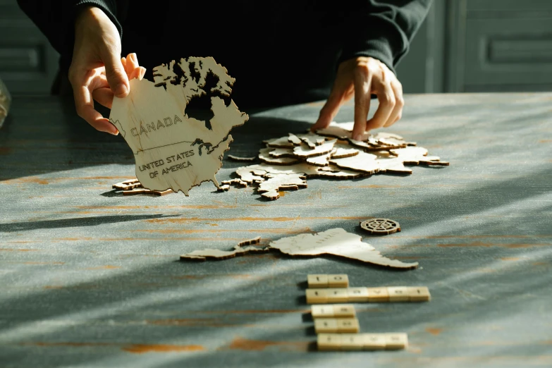 someone holding up a piece of wood on a table