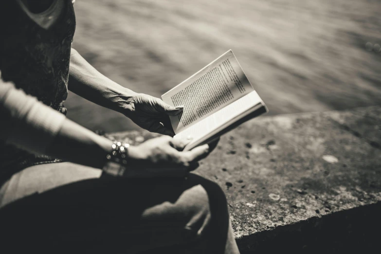 a woman sits on steps, reading a book