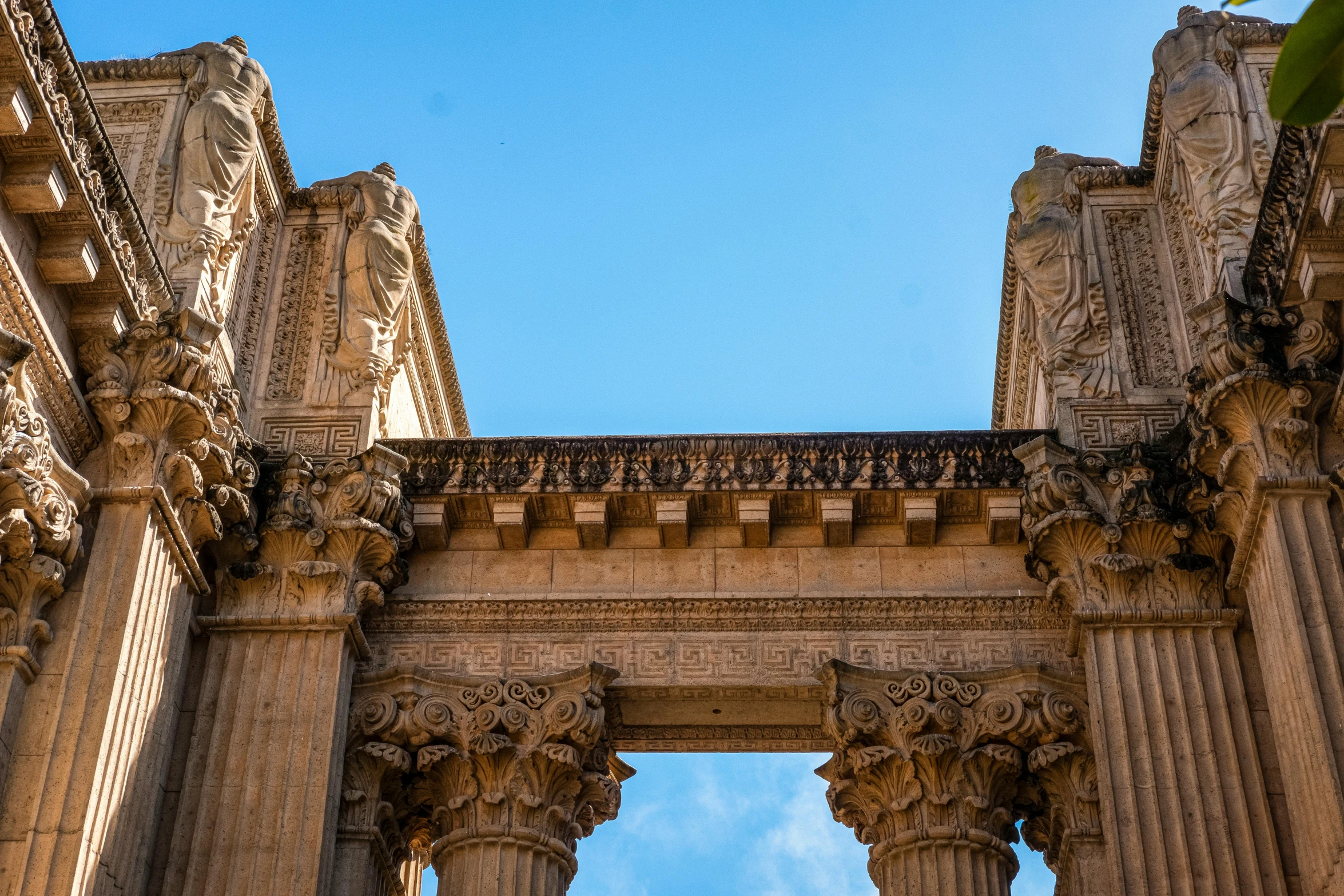 the facade of an ancient building under a blue sky