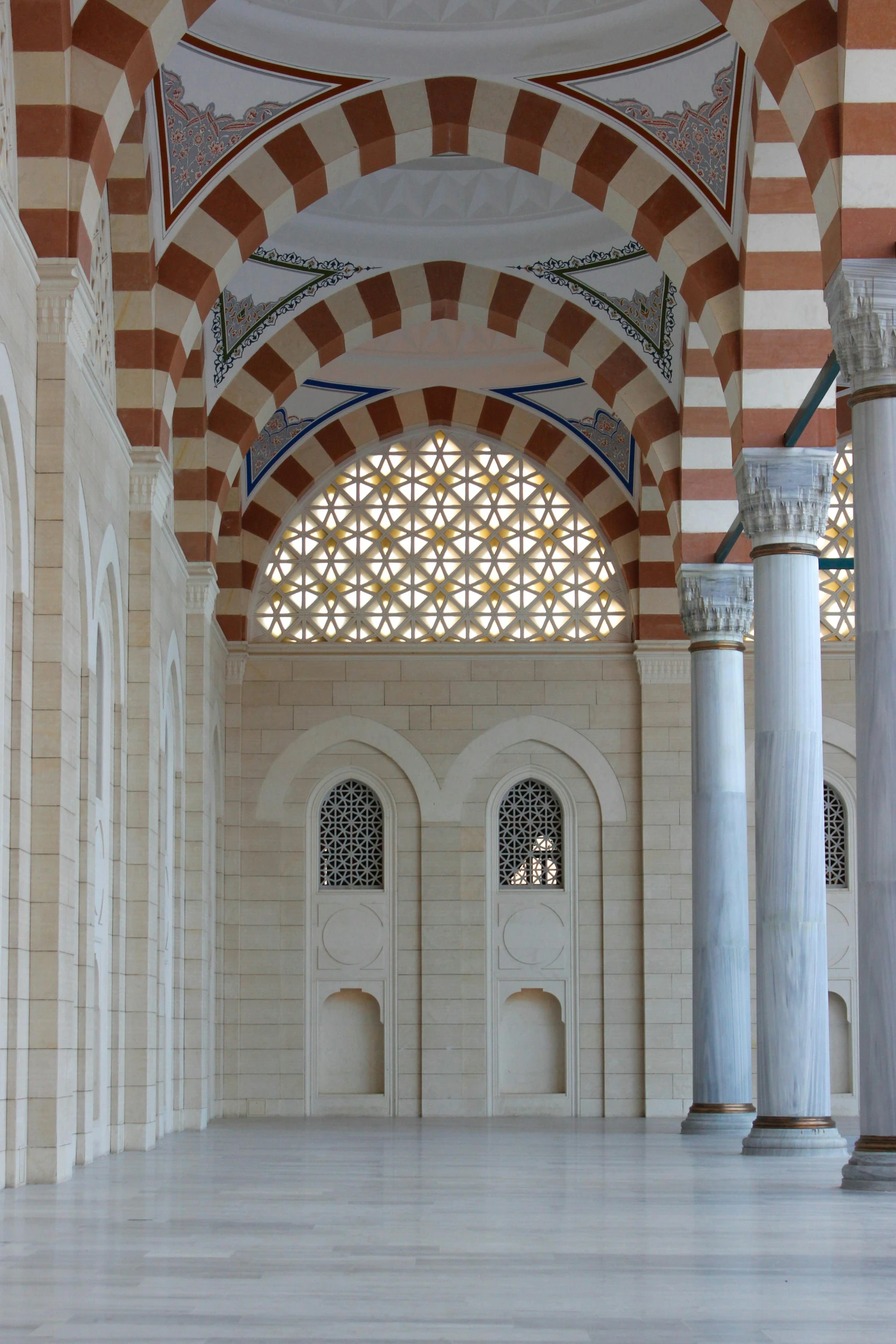 an interior view with columns and arches, an arch in the center and some windows